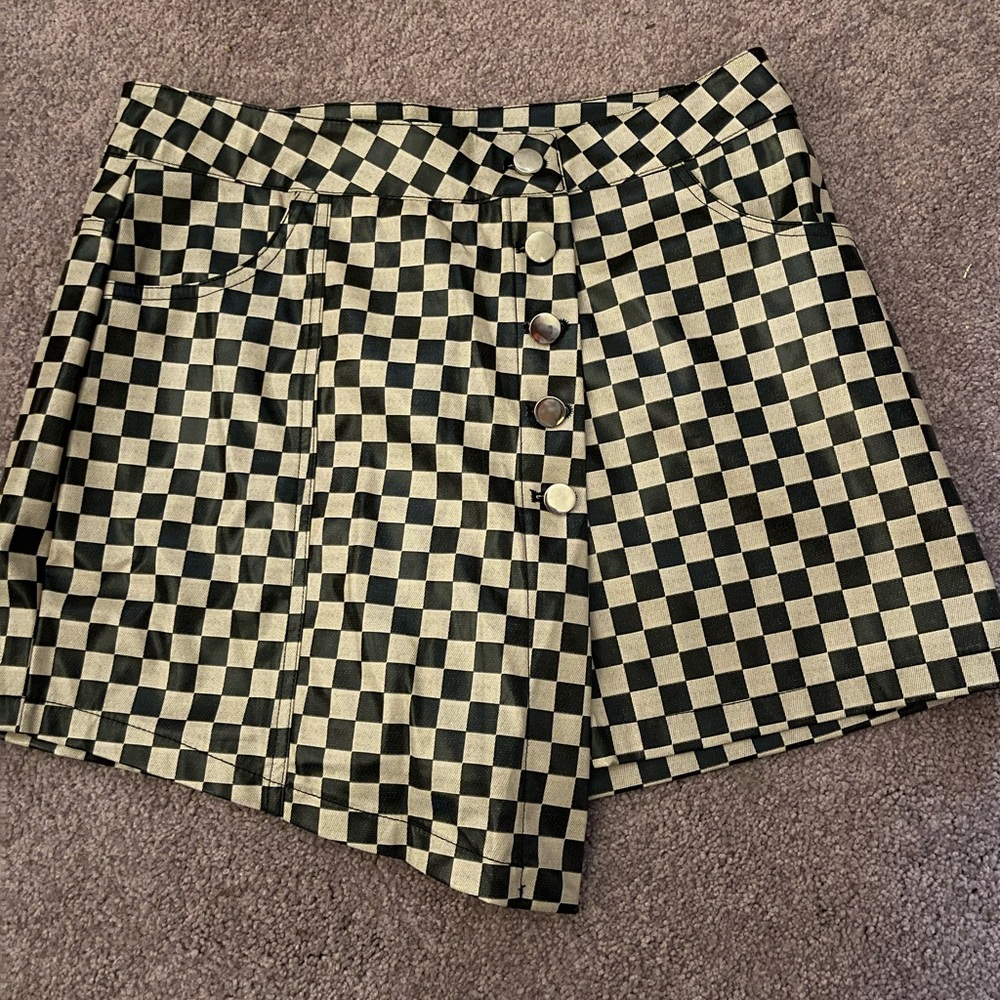 Vinyl A- Symmetric checkered skort. Has silver buttons and a zipper in the front